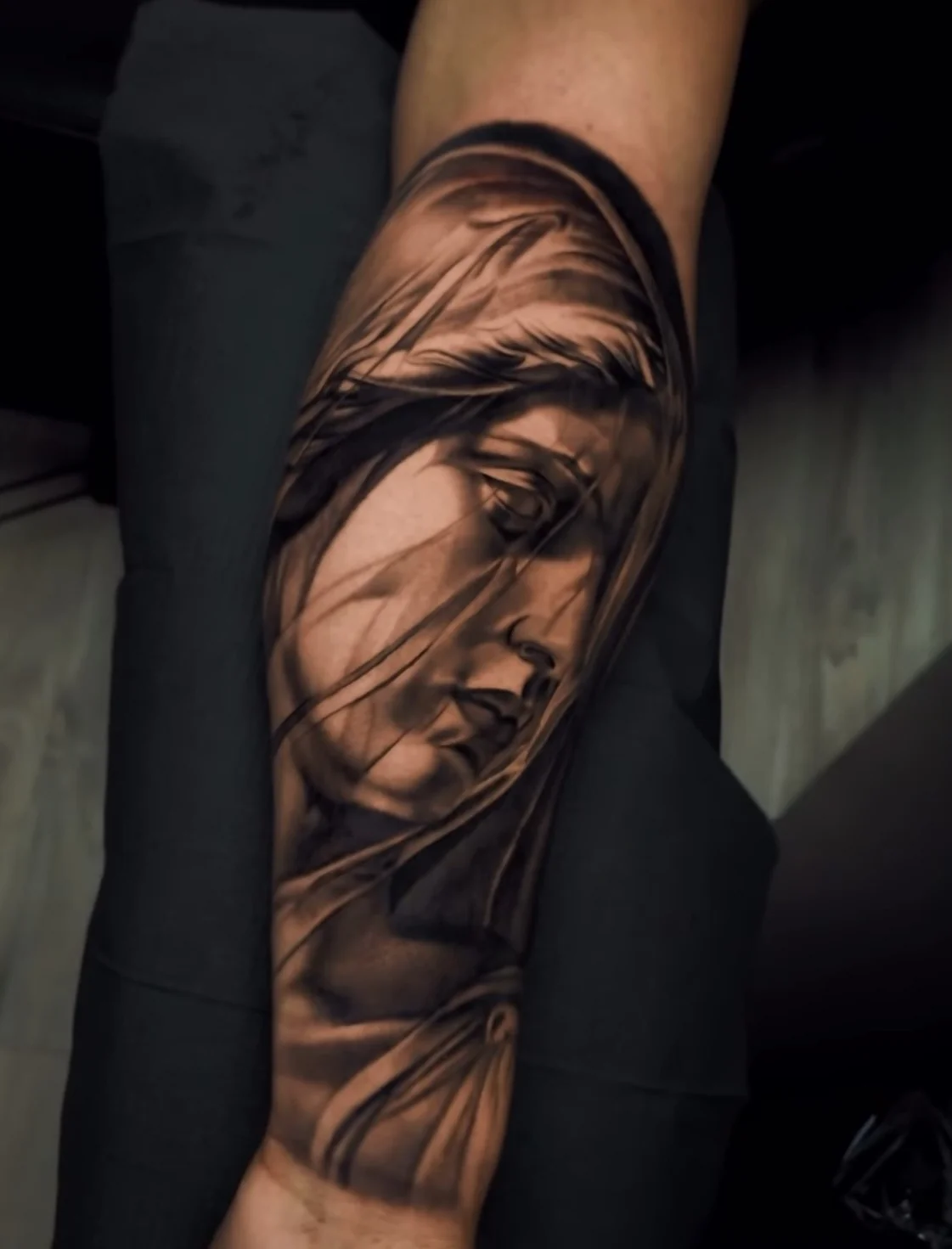 Black and grey realism tattoo detail on a forearm